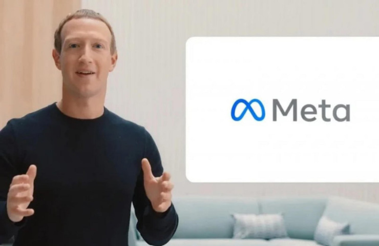 Mark Zuckerberg che parla con vicino uno schermo di Meta col logo blu